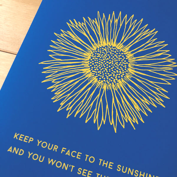 antdesigngifts.co.uk Sunflower art print with blue background and yellow flower. Quote Keep you face to the sunshine and you won't see the shadows. Ukraine flag colours. Blue and yellow. Charity print.
